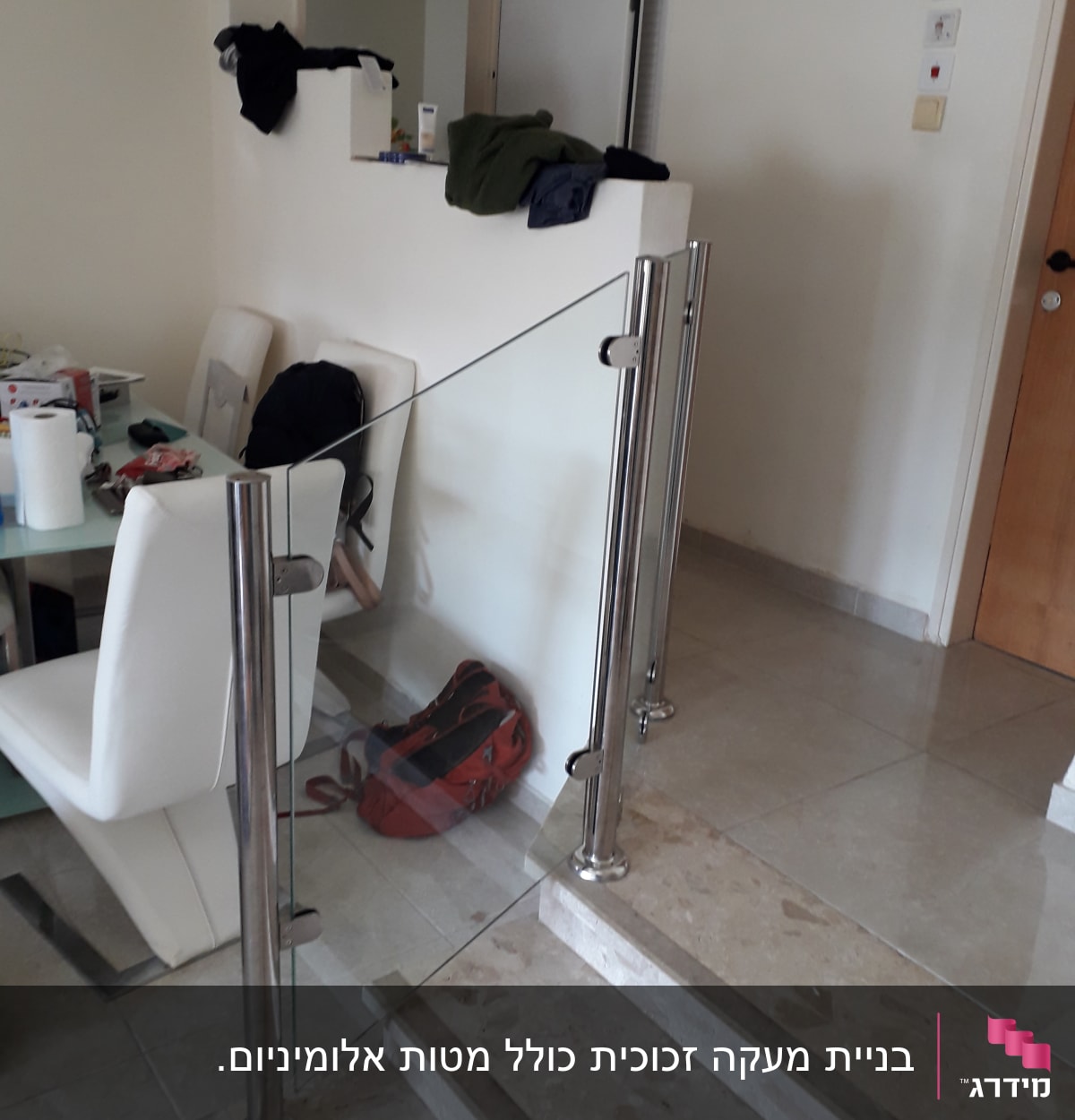 מעקה זכוכית עם עמודי מתכת על מדרגות